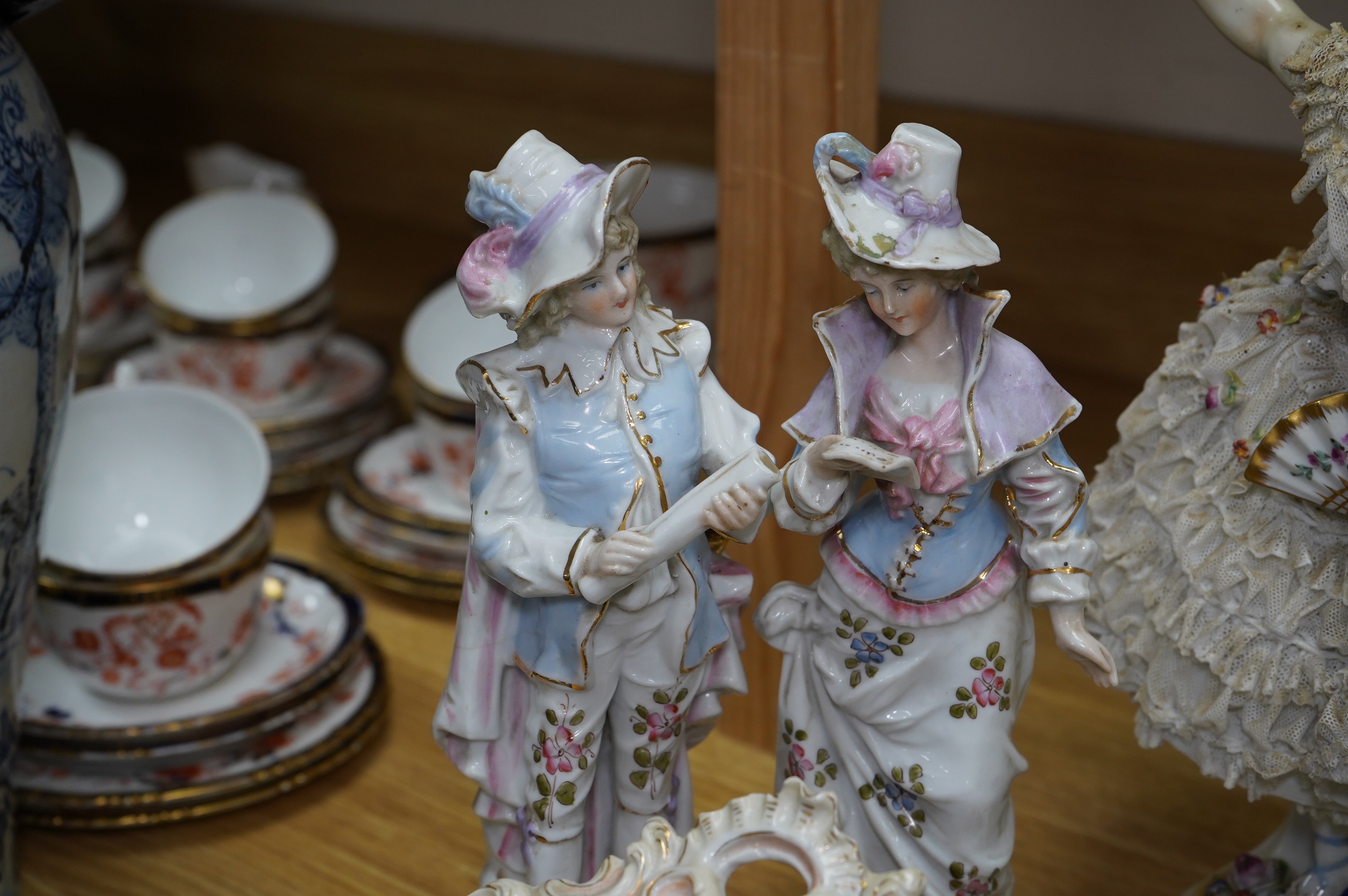 A collection of Continental porcelain ceramic figurines, including a pair of lace examples, dancing ladies and an easel mirror, largest 29cm high. Condition - mostly poor